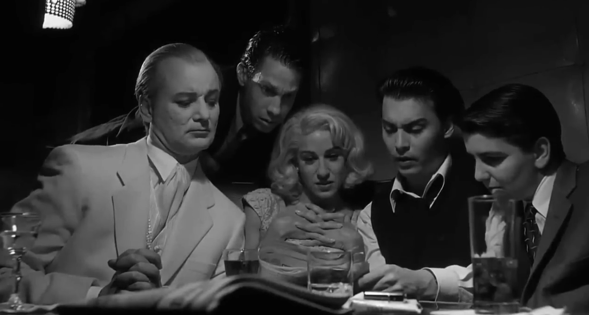 A scene from the 1994 film "Ed Wood" where Wood and his friends and collaborators are sitting at a table reading a bad review from a newspaper.