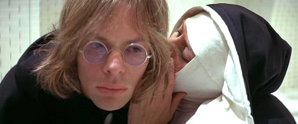 The nun Jeanne des Agnes whispering in the ear of the witch-hunter Pierre Barre in the 1971 film The Devils.